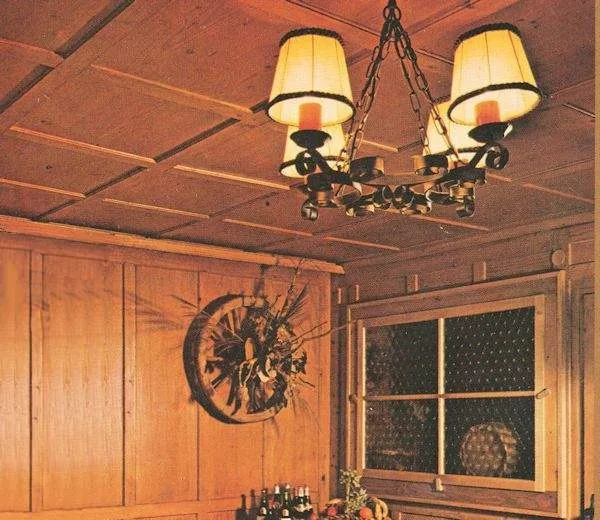 Der Raum Museum mit alten Fichtenkassetten an Decke und Wänden, schmiedeeisernem Luster und einem Wagenrad