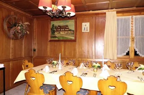Festlich gedeckte lange Tafel in einer holzvertäfelten Stube, an der Wand ein Gemälde des Hauses
